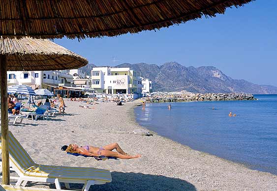 KARDAMENA BEACH - Woman sunbathing at Kardamena beach
