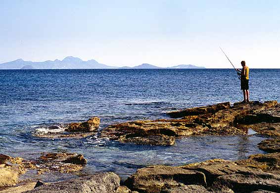 Lonely fisherman - A man fishing from the rocks next to Kardamena beach